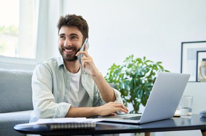 Man at computer with phone